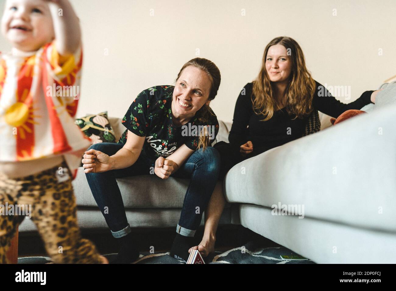 Female couple sitting on sofa Stock Photo