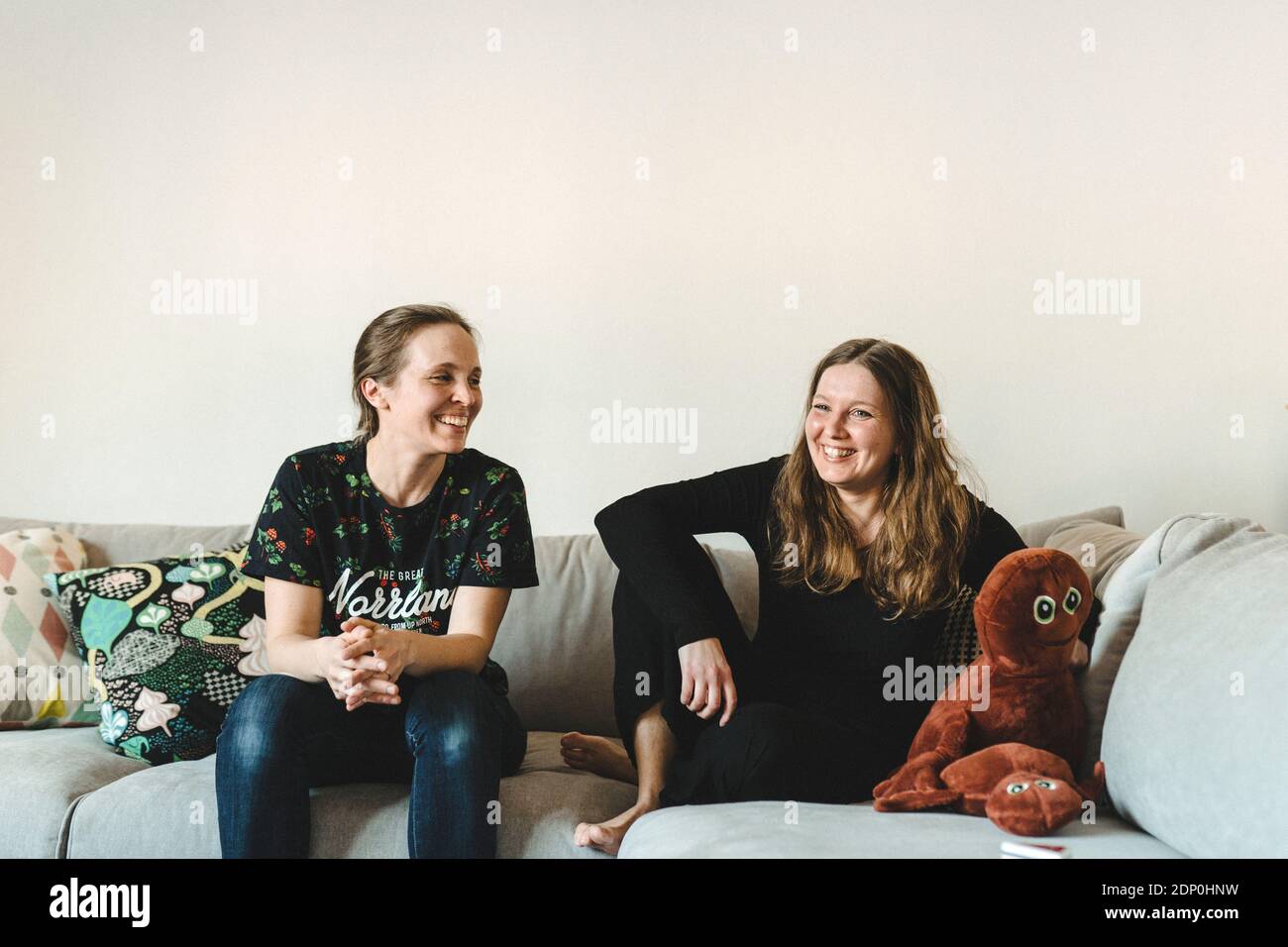 Female couple sitting on sofa Stock Photo