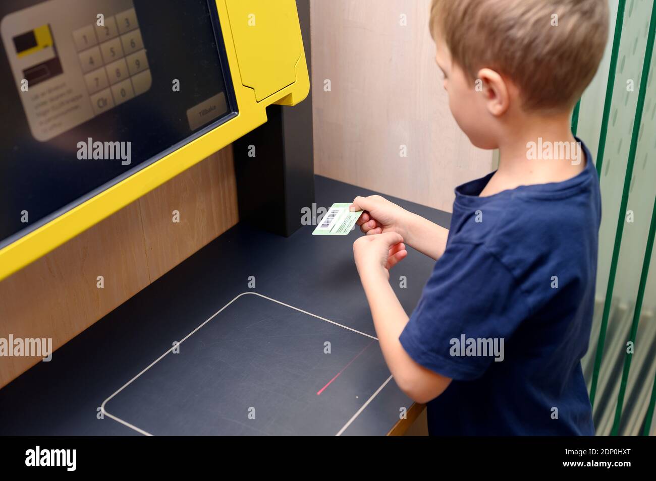 Boy using self service point in library Stock Photo