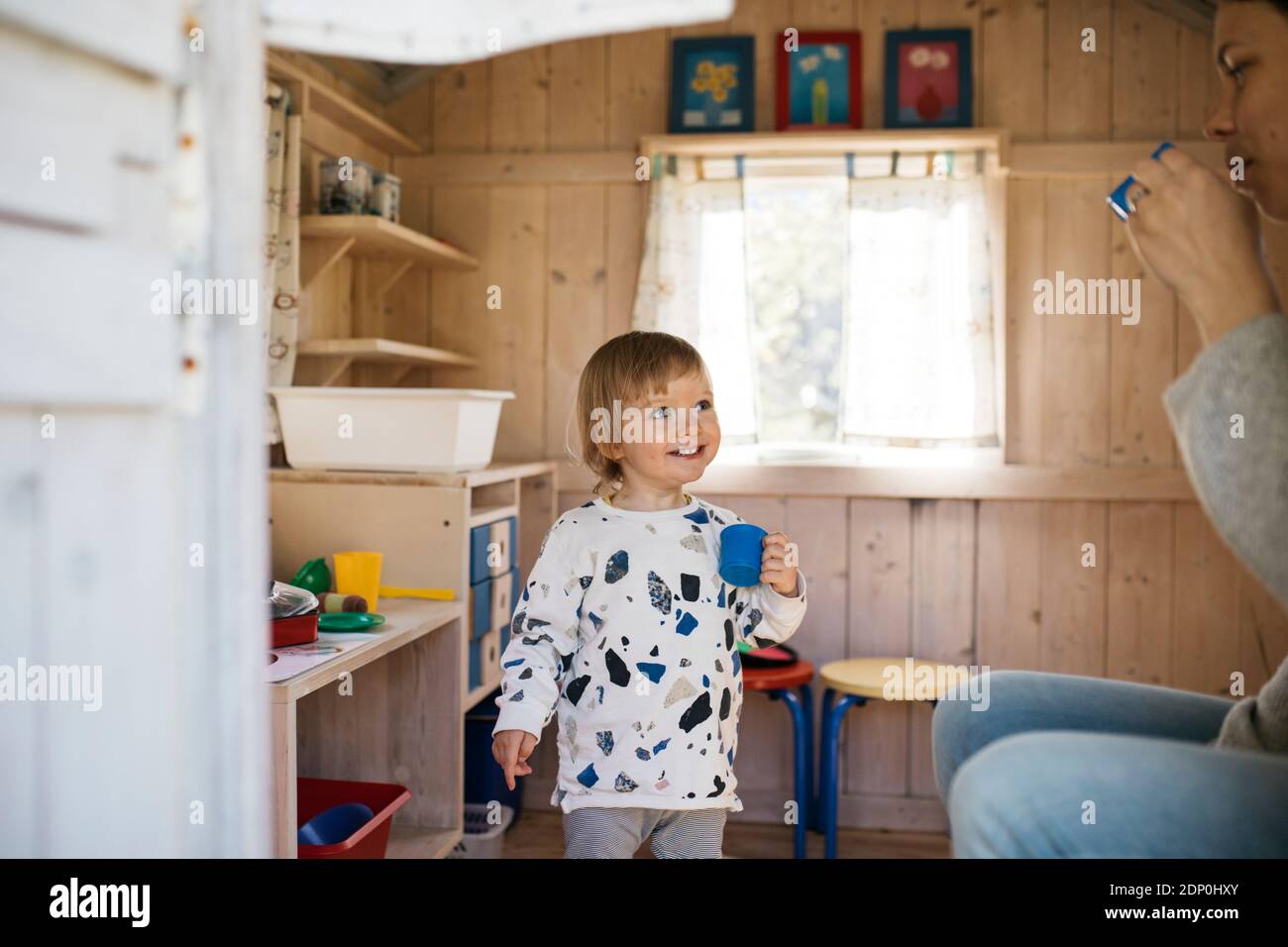 Toddler girl in playhouse playing tea party with mother Stock Photo Alamy