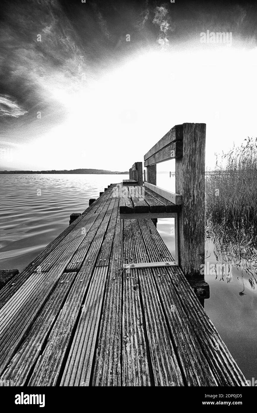 December 16, 2020, Schleswig, a weathered wooden pier with banks as the sun slowly sets on the banks of the Schlei. | usage worldwide Stock Photo