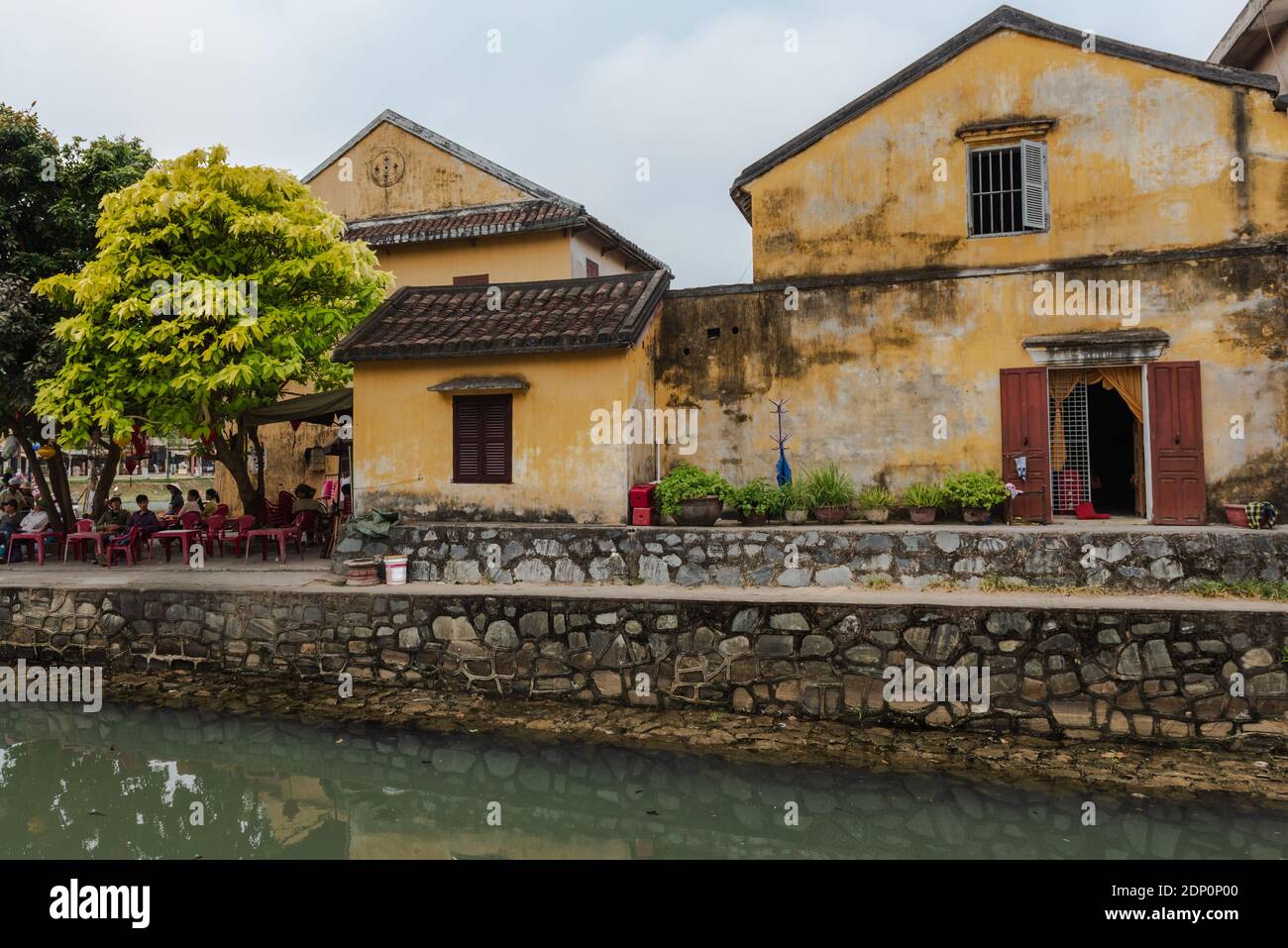 Hon Gai, Vietnam -- March 23, 2016. A wide angle photo that includes an outdoor dining patio, a restaurant and house by the waters of Ha Long Bay. Stock Photo