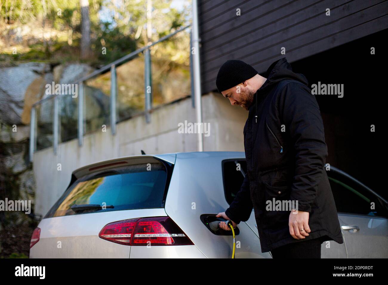 Man charging electric car Stock Photo