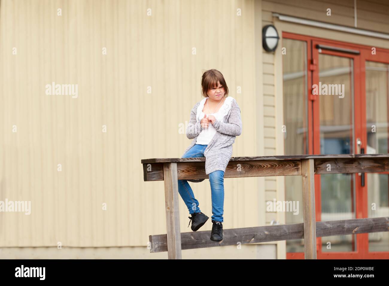 Girl sitting in front of school building Stock Photo - Alamy