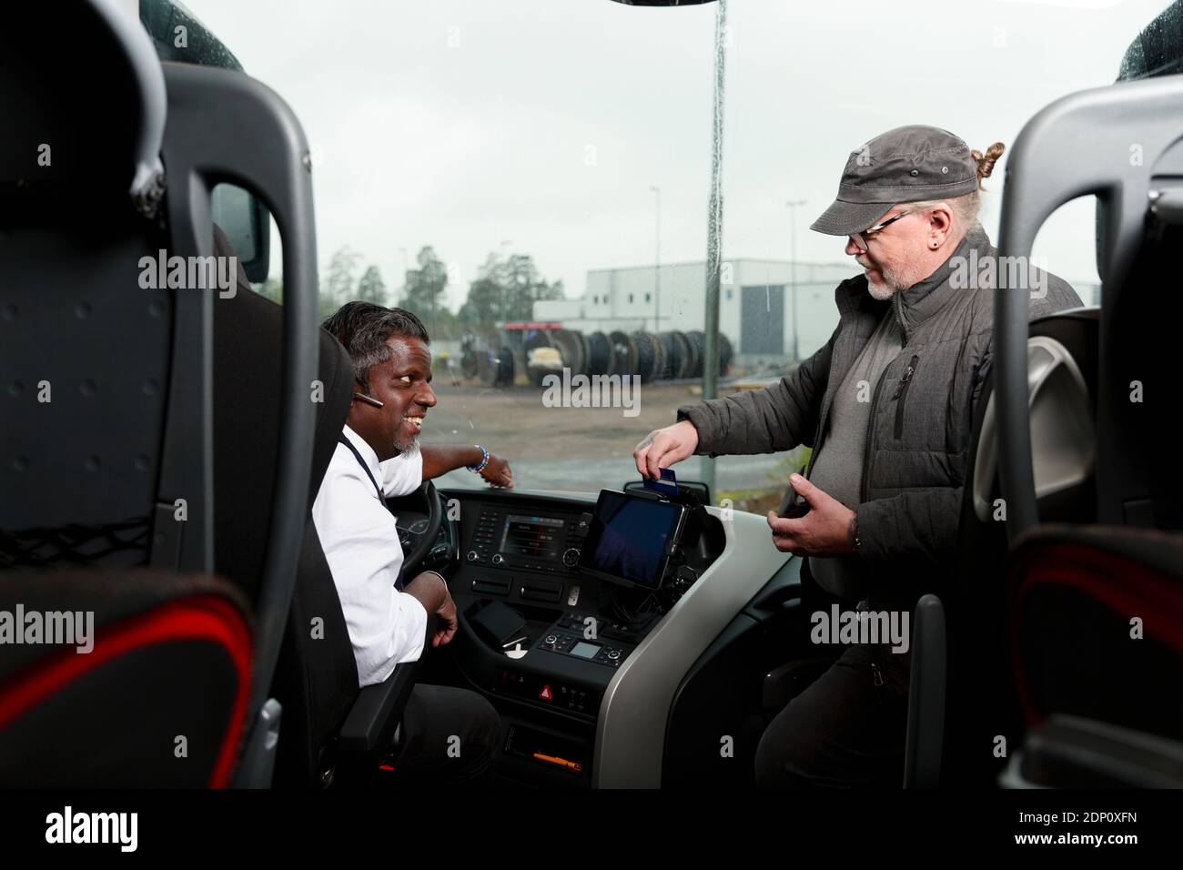 Passenger talking to driver in bus Stock Photo