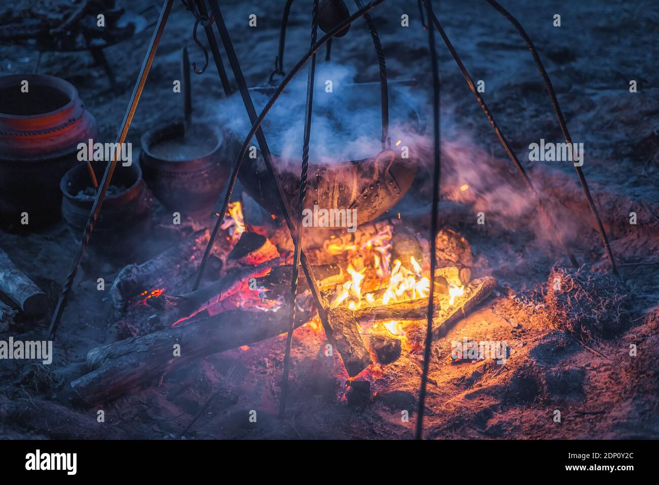 Selective focus on boiling cauldron with mysterious decoction on a campfire at night witch sabbath. Kupala Night, called in Poland Noc Kupaly, Cedynia Stock Photo