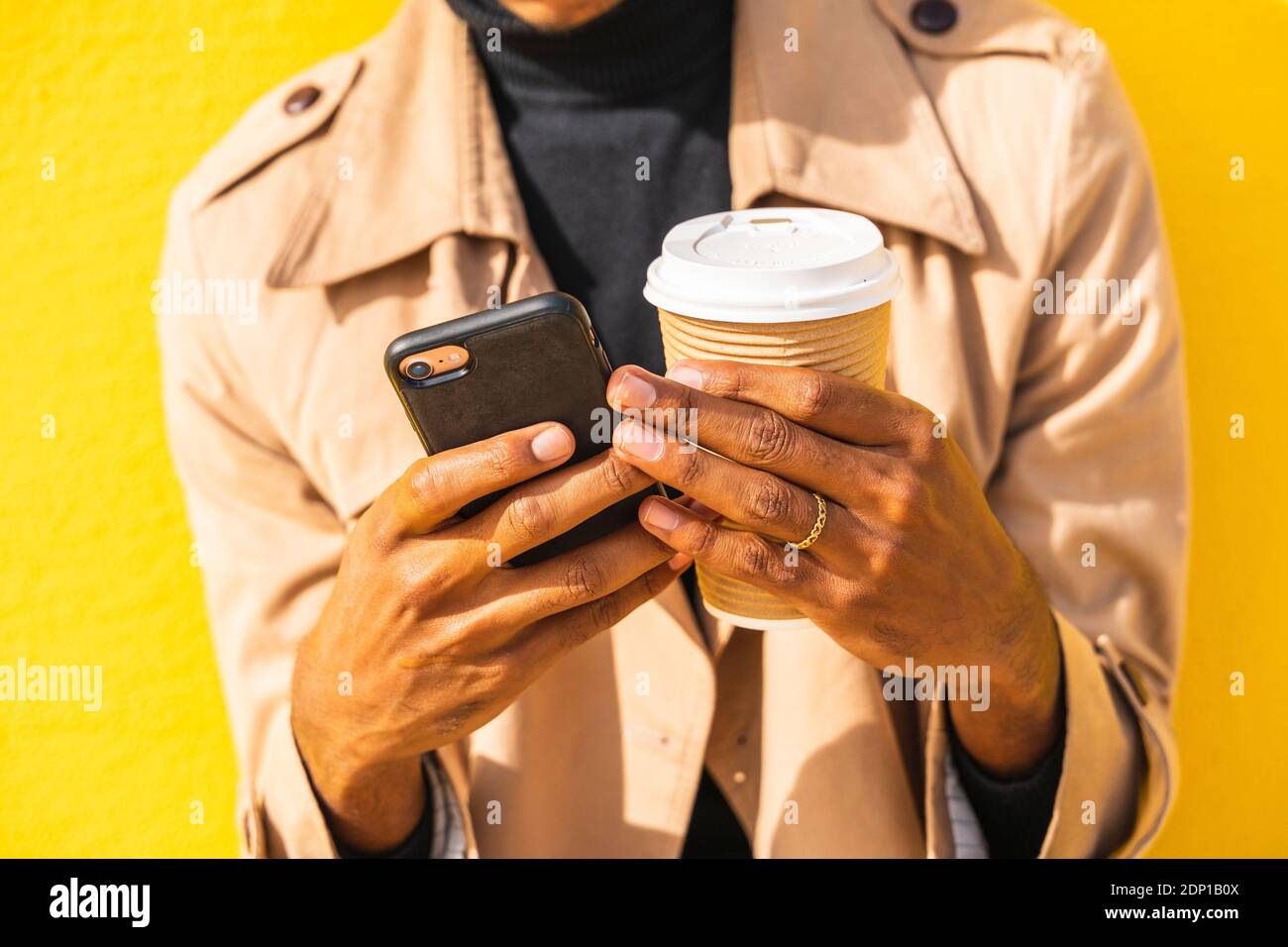 Young man with coffee cup, using smartphone Stock Photo