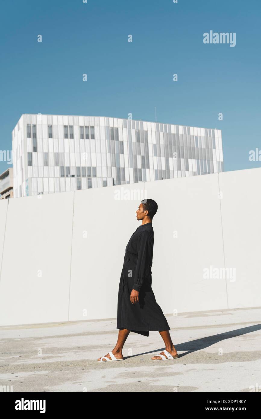 Young man wearing black kaftan standing outdoors Stock Photo