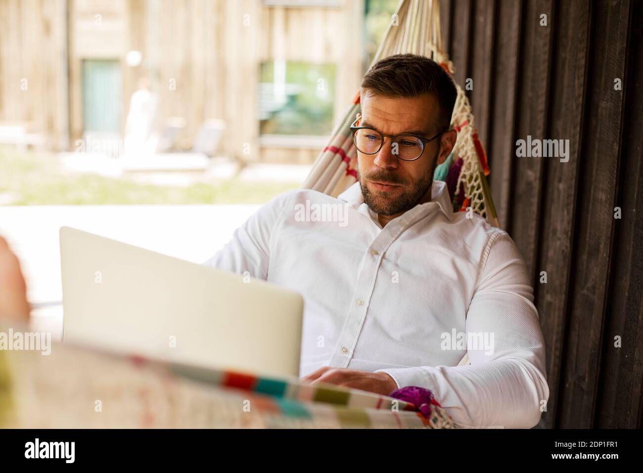 Man on hammock using laptop Stock Photo