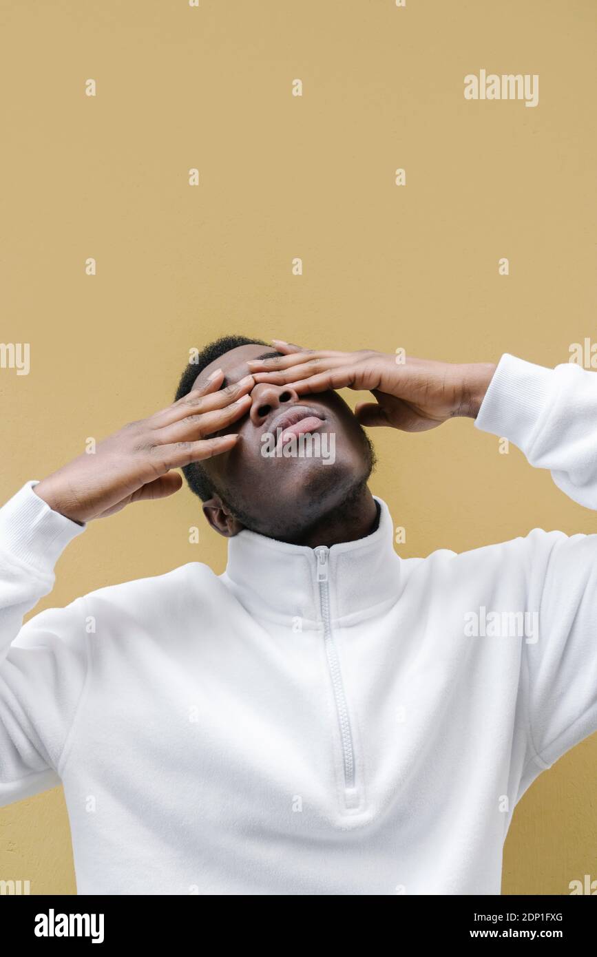Portrait of man with head back covering his eyes Stock Photo