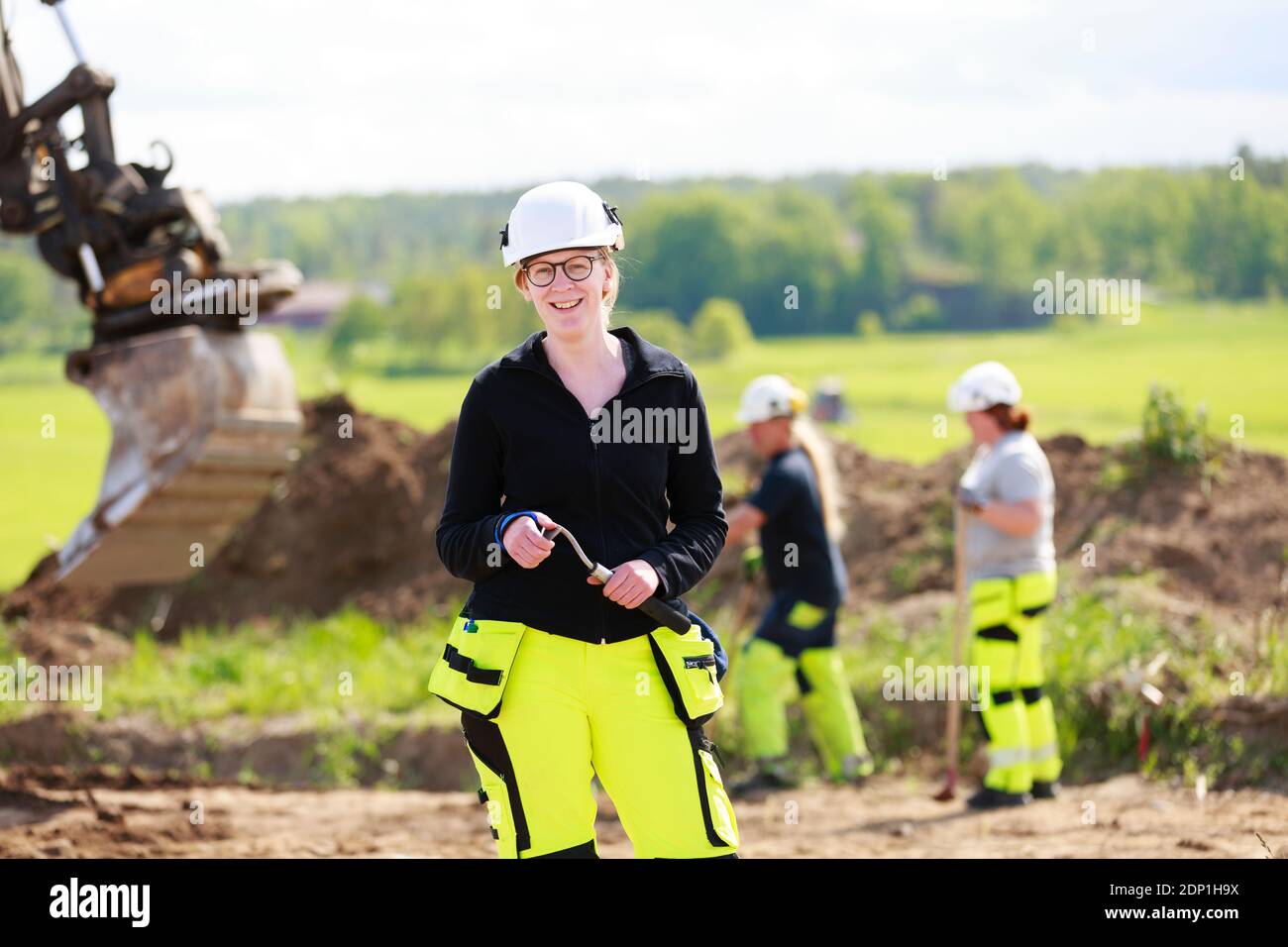 Female worker with digger on background Stock Photo