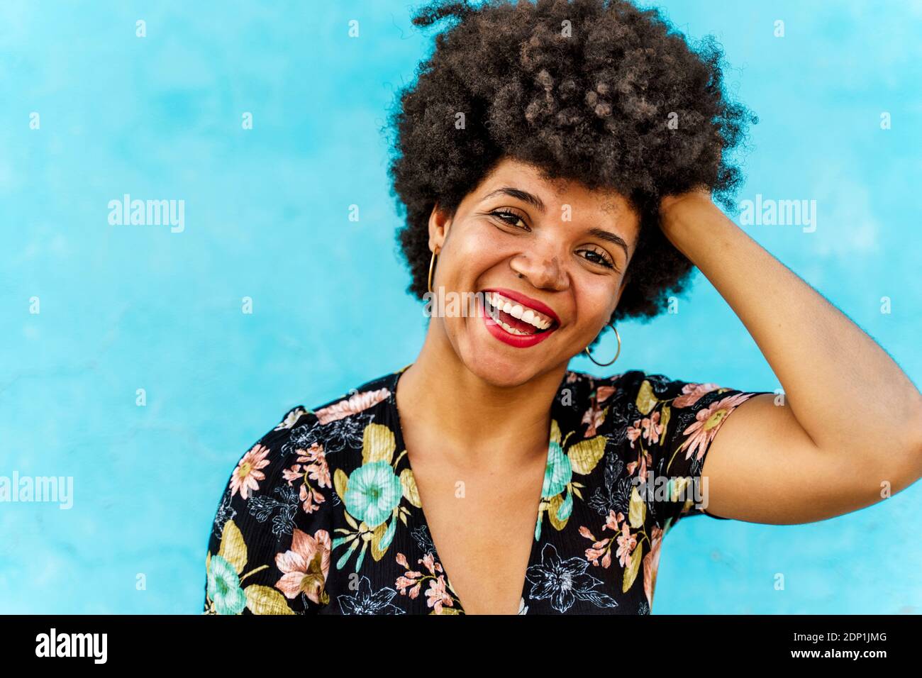 Portrait of smiling female Afro-American woman, hand in hair Stock Photo