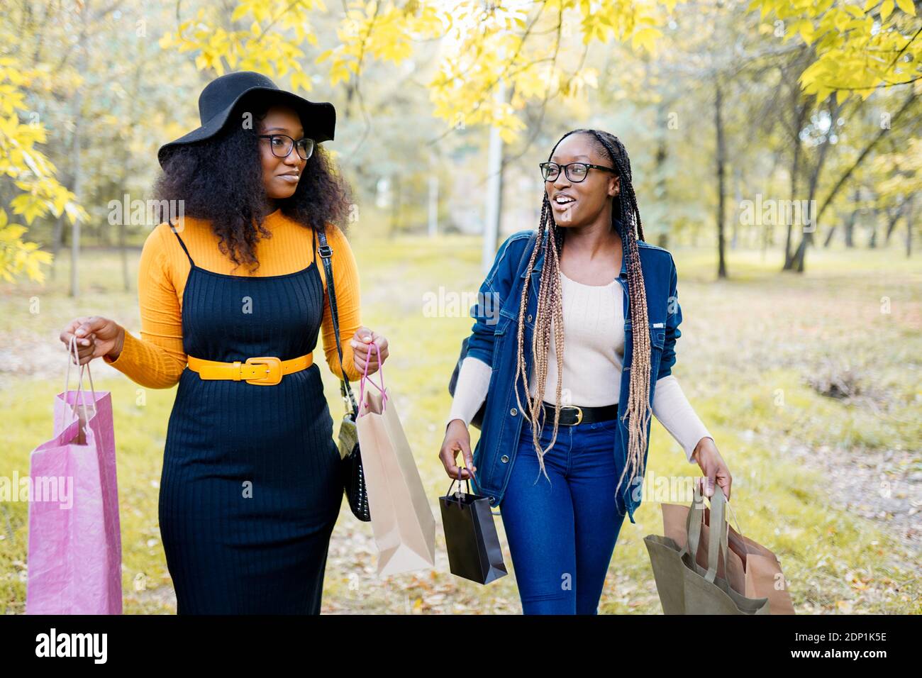 beautiful young black women smiling with shopping bags outside Stock Photo