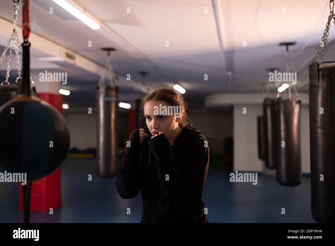 Determined woman in sportswear standing in fighting stance and hitting