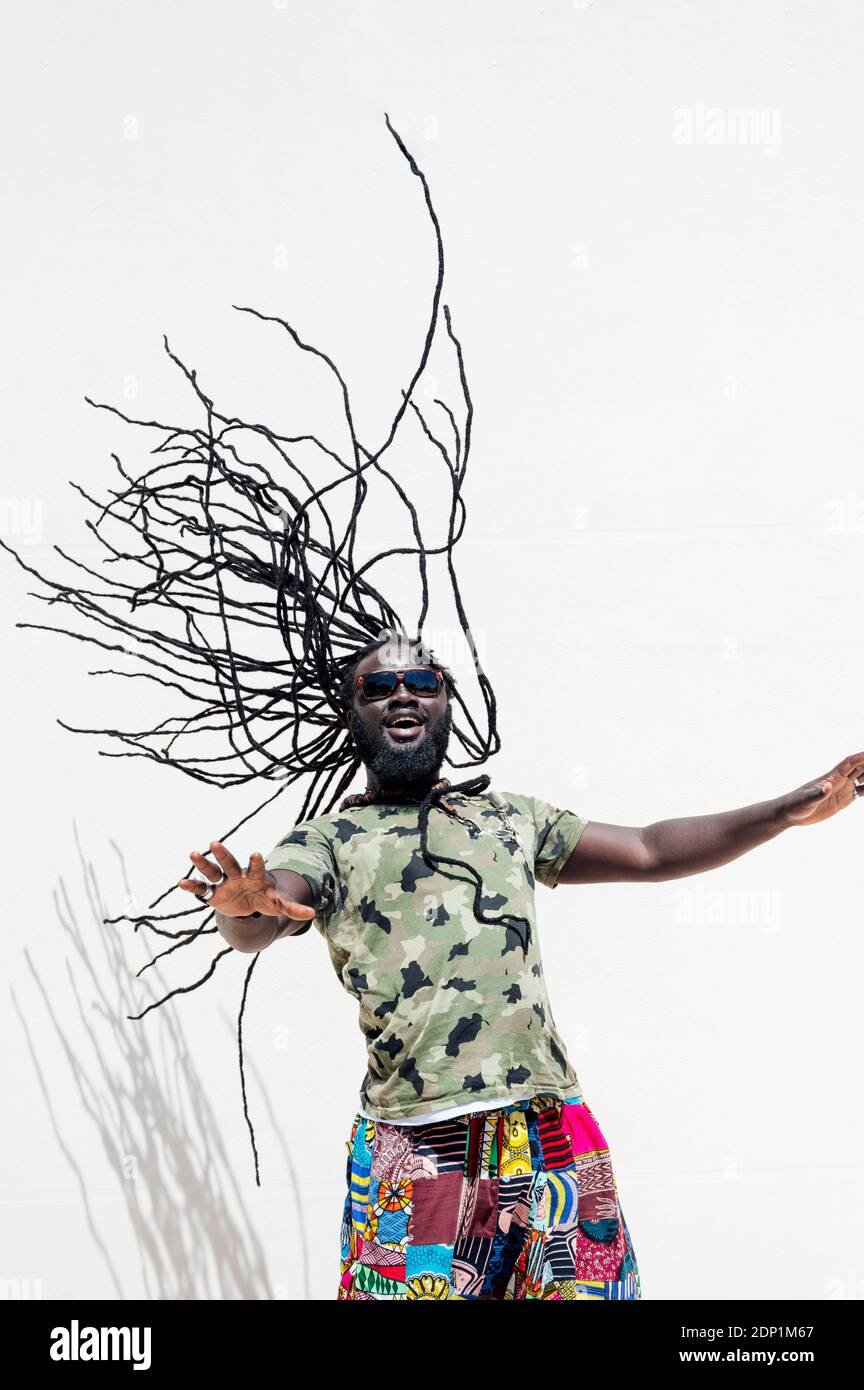 Rastafari man with sunglsasses tossing his dreadlocks Stock Photo