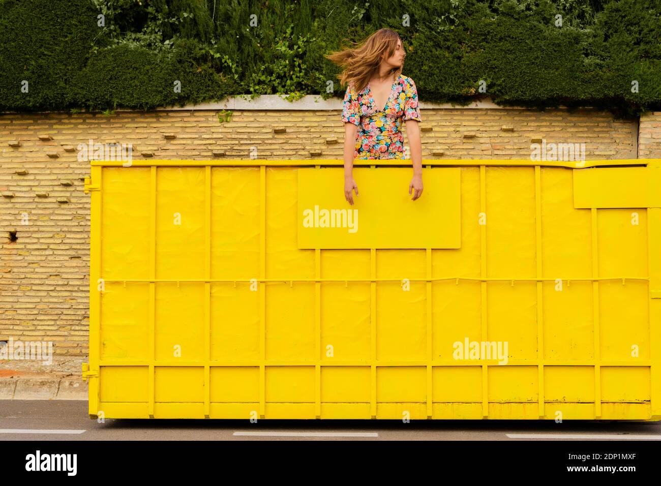 Woman standing in yellow container, looking around Stock Photo - Alamy