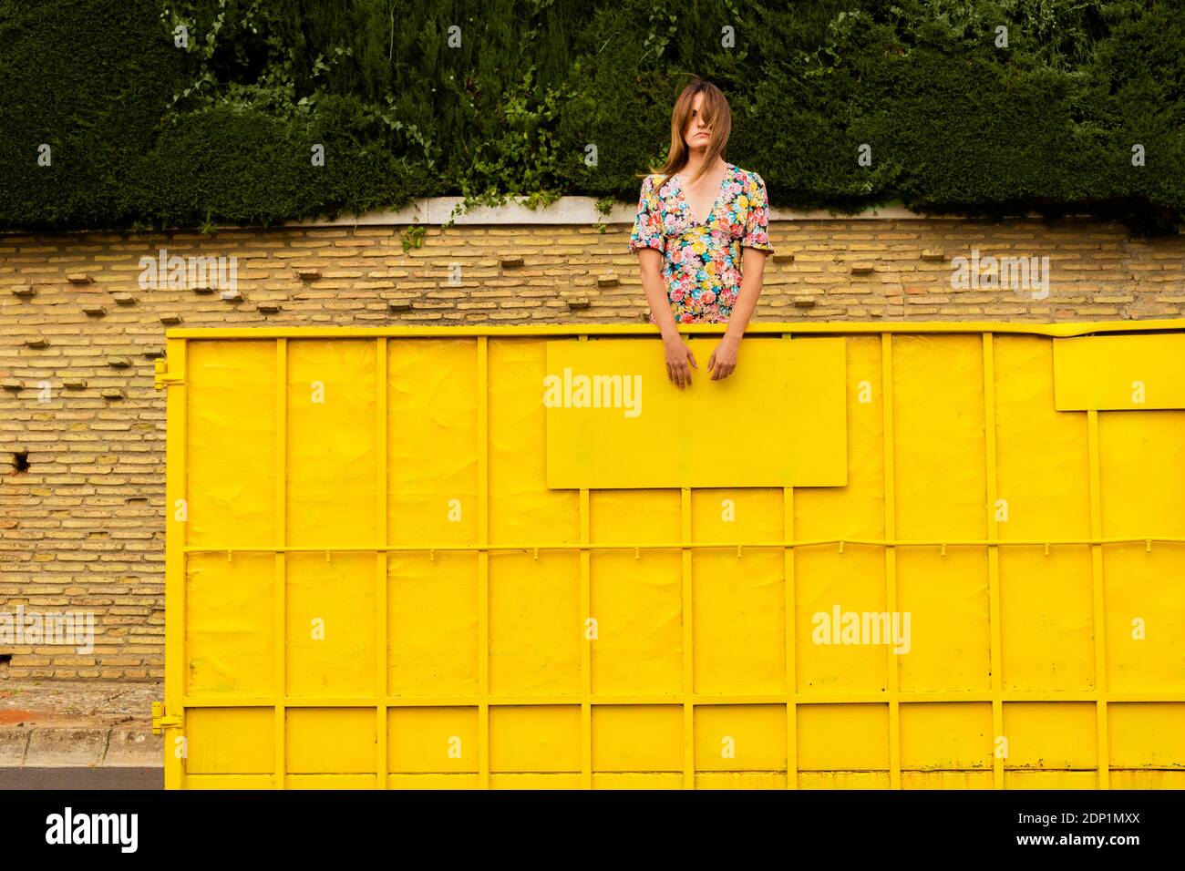 Woman standing in yellow container, looking around Stock Photo - Alamy