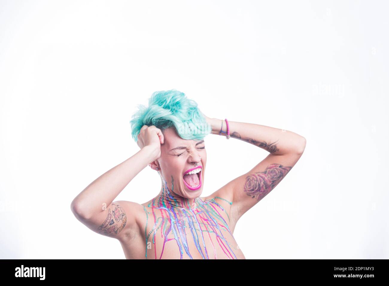 Beautiful woman with blue hair and body paint, screaing and tearing her hair out Stock Photo