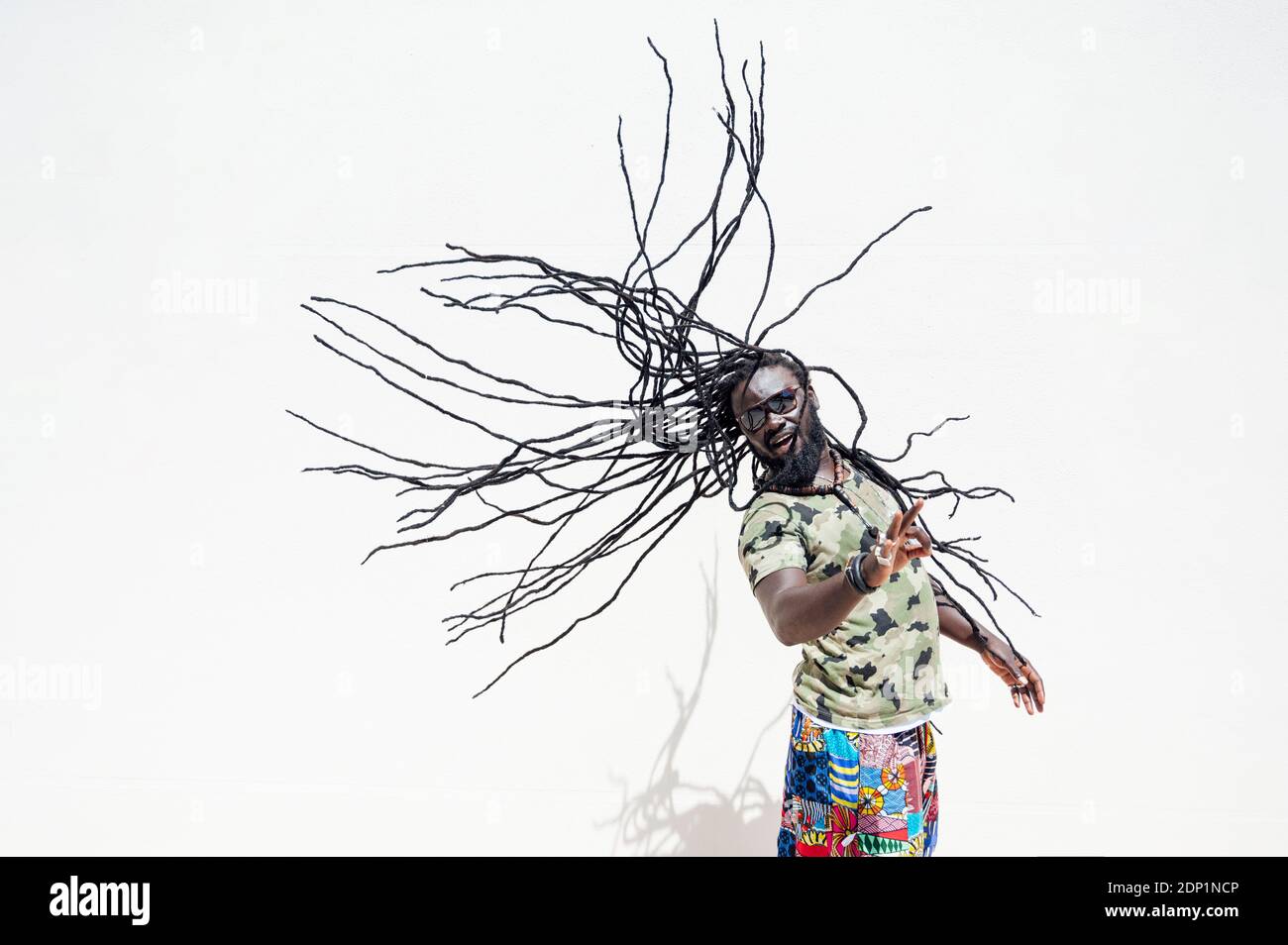 Rastafari man with sunglsasses tossing his dreadlocks Stock Photo