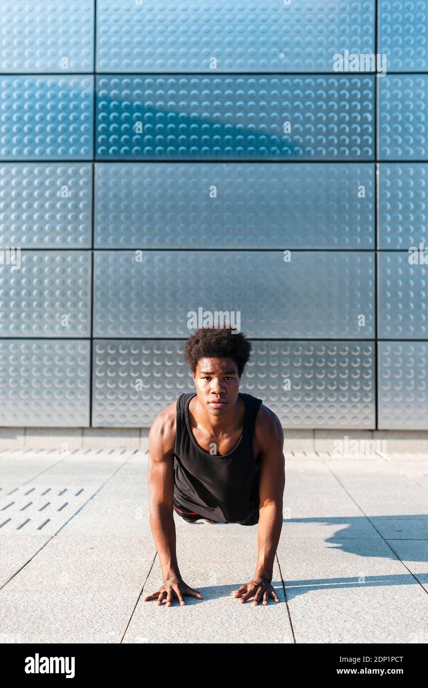 Spain, Madrid, Young athletic Afro man doing push ups in urban area, Youth, Ethnicity, Healthy, Sport Stock Photo
