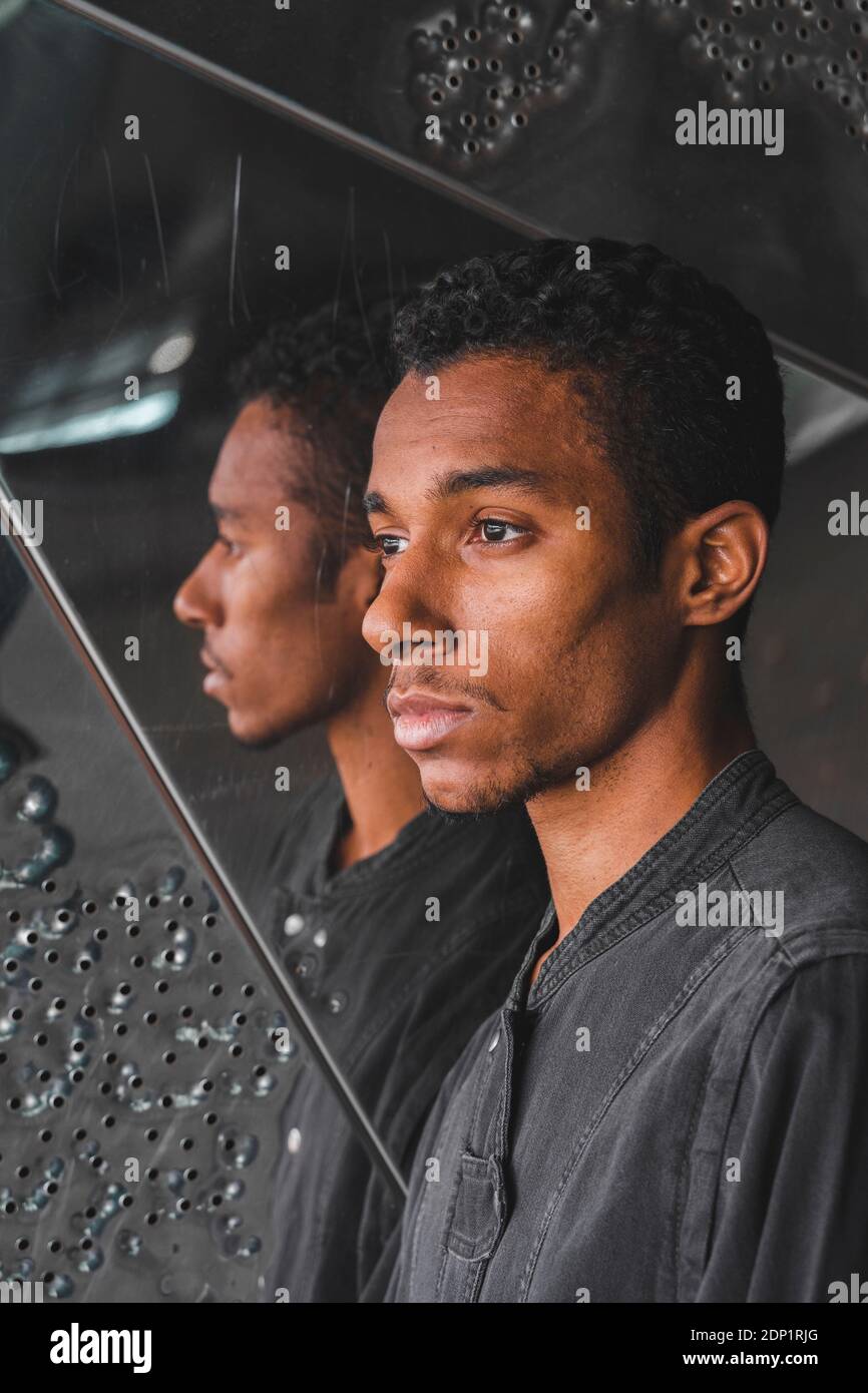 Portait of young man at mirrored wall Stock Photo