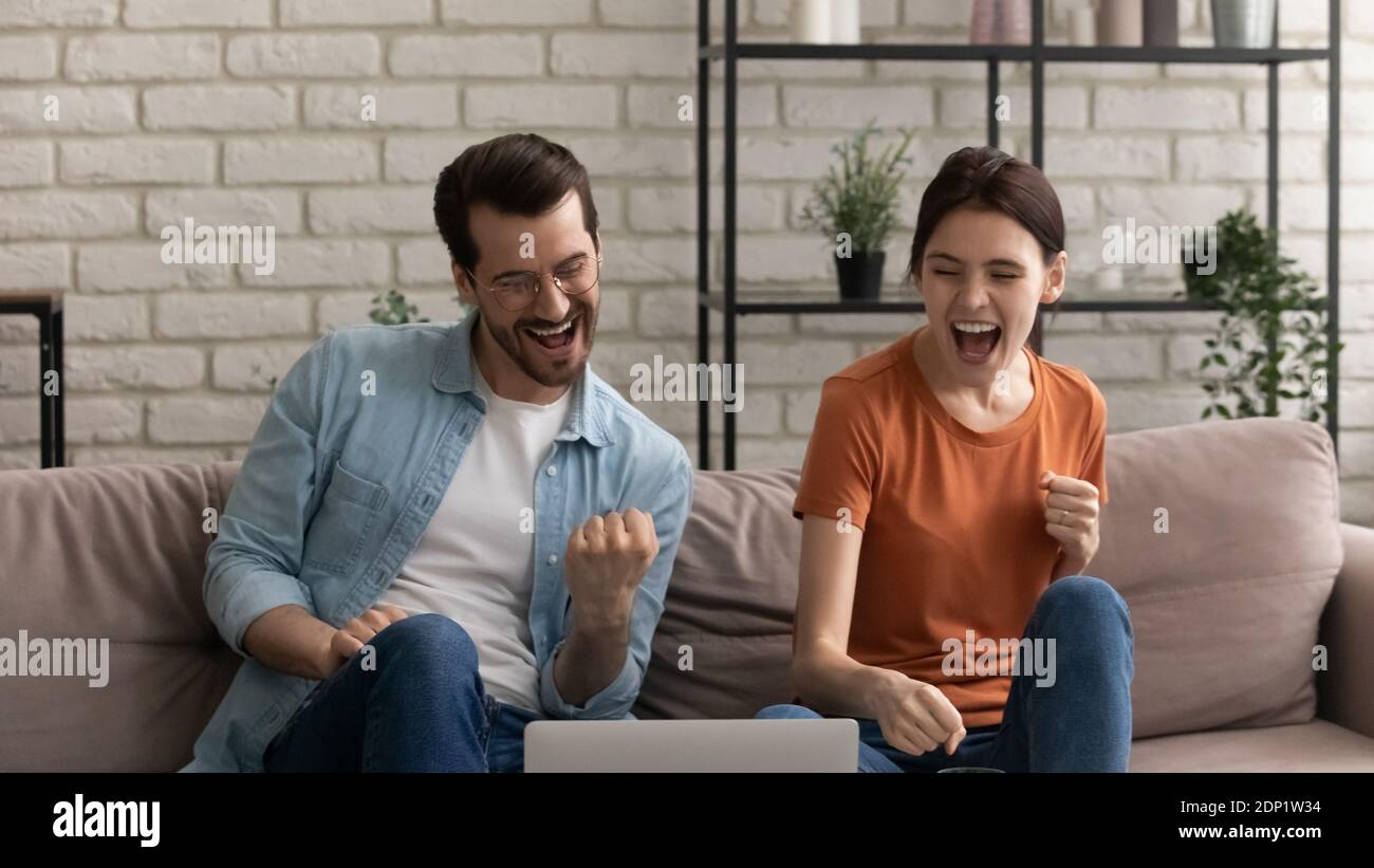 Happy young spouses getting email with loan approval from bank Stock Photo