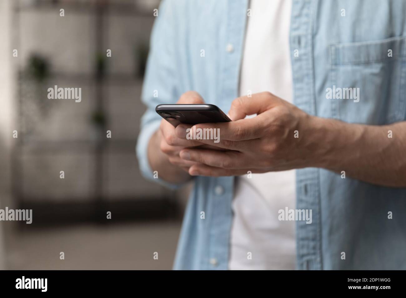 Male hands holding smartphone touching sensor screen browsing internet Stock Photo