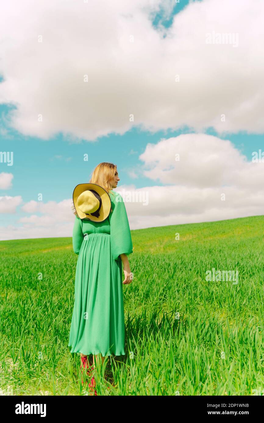Back view of woman wearing green dress standing on a field Stock Photo ...