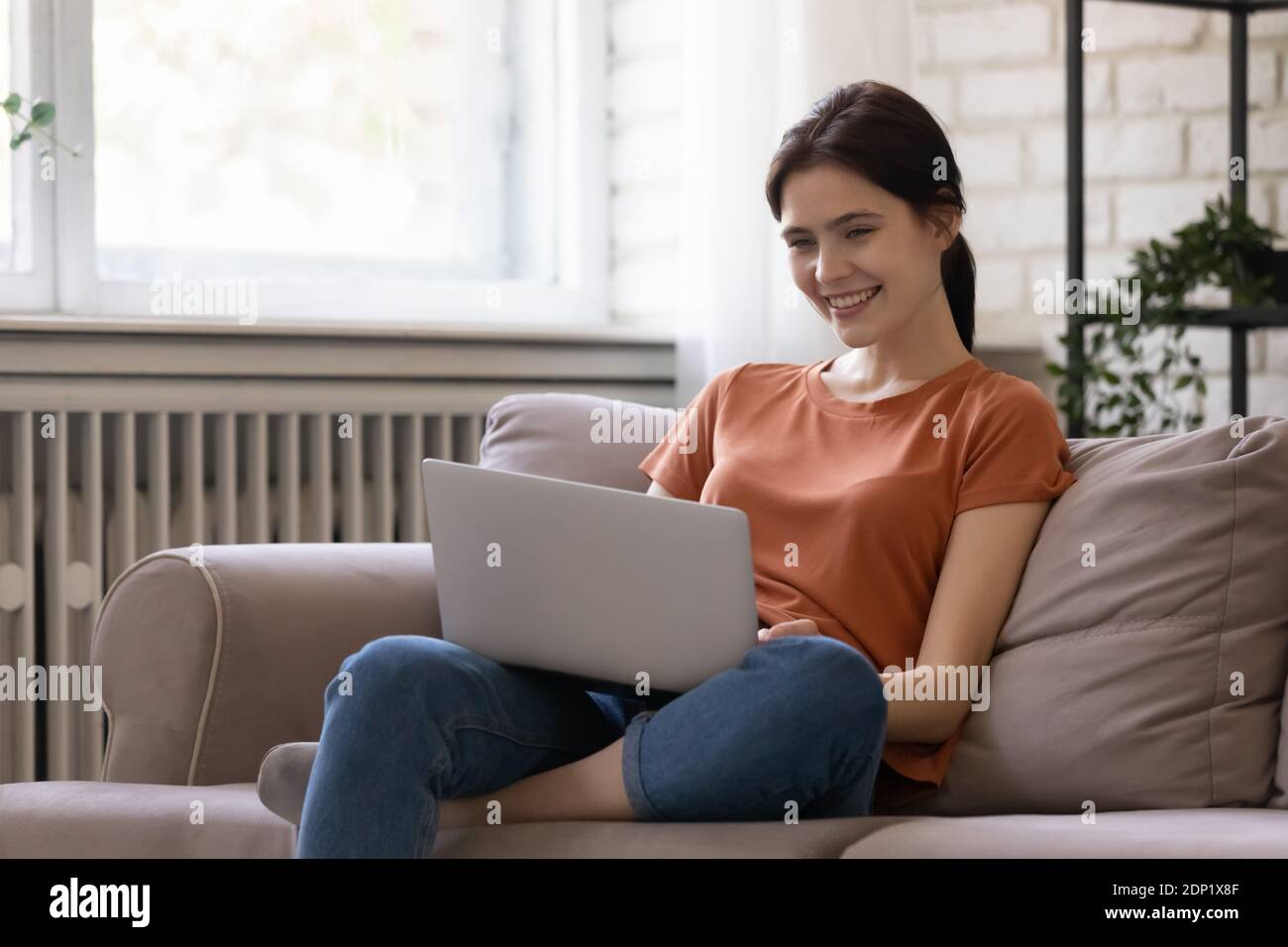 Young woman spending time indoors at quarantine period communicating online Stock Photo