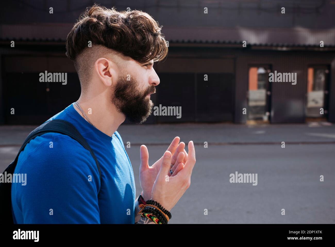 Young bearded man walking through the city Stock Photo
