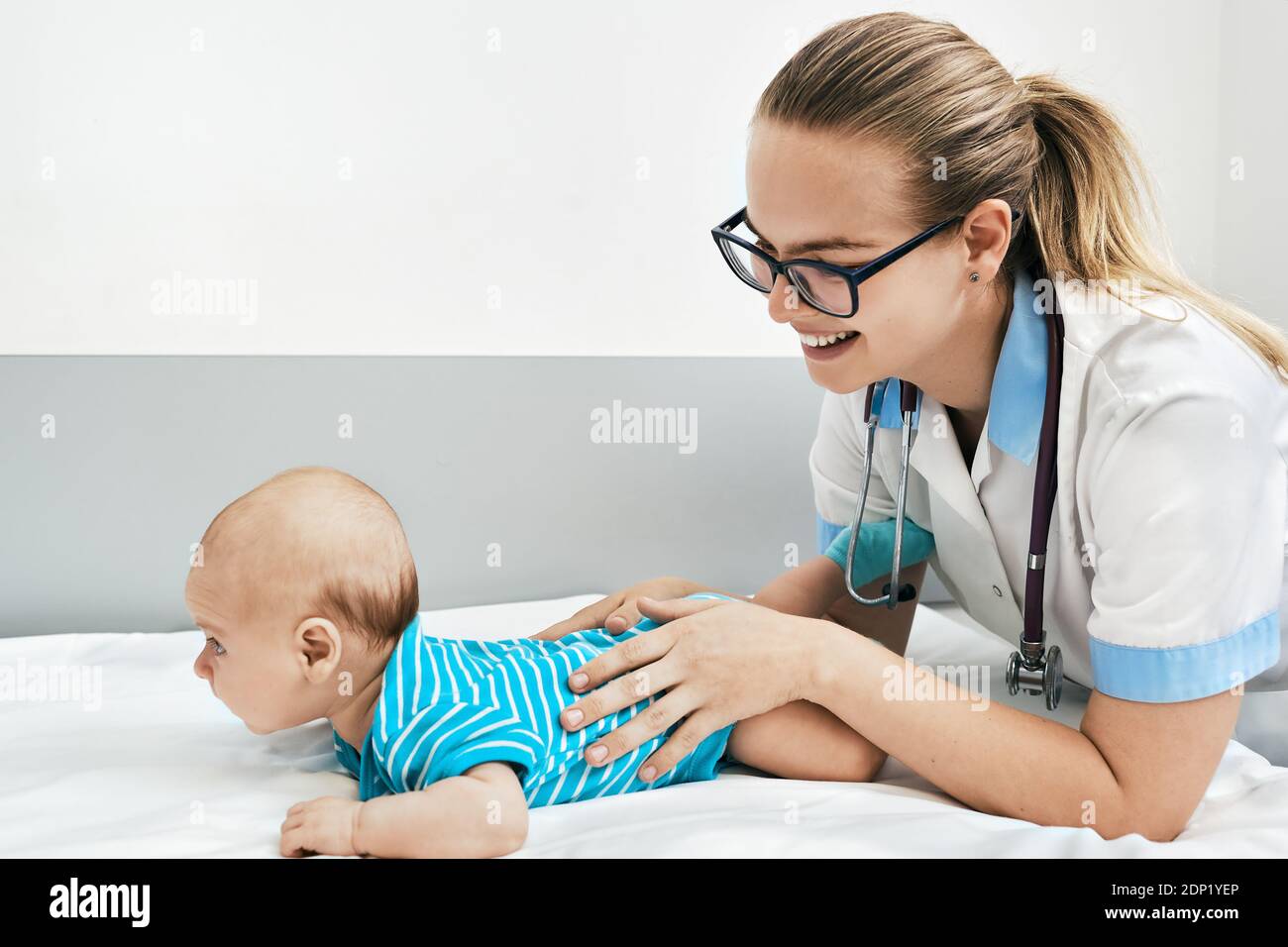 doctor examines infant baby 3-month-old. Smiling pediatrician communicate and playing with baby at the hospital Stock Photo