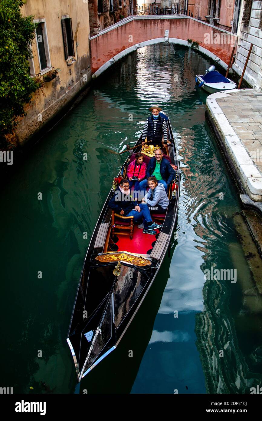 A Family Taking A Gondola Ride, Venice, Italy. Stock Photo