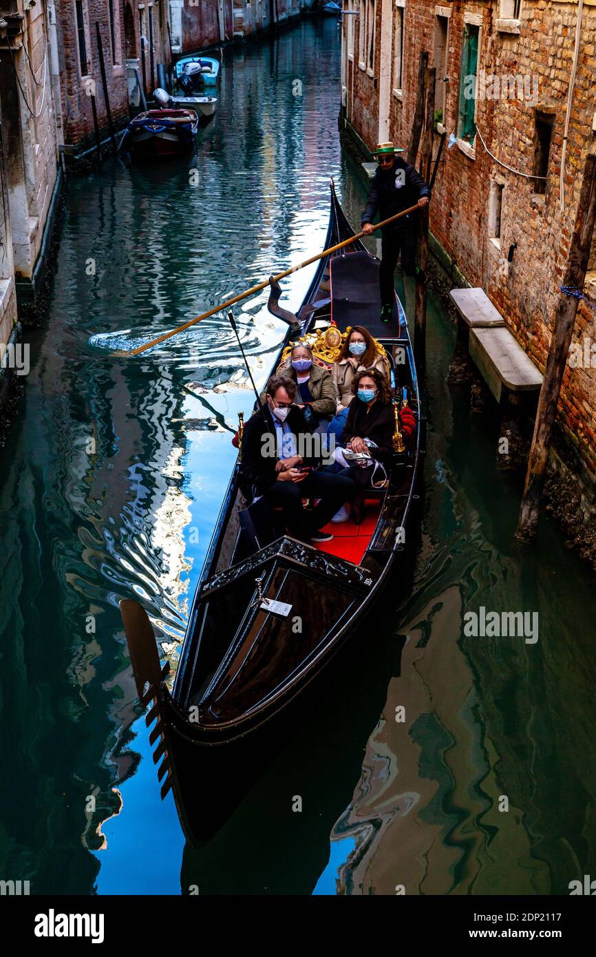A Family Wearing Face Masks Take A Gondola Ride During The Covid 19 Pandemic, Venice, Italy. Stock Photo