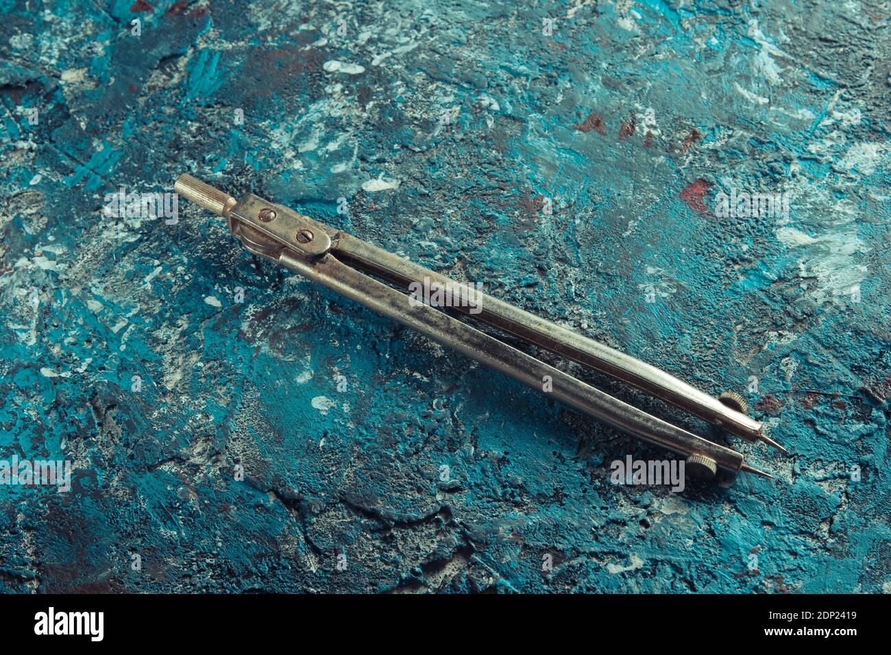 Old compass drawing on a blue concrete background Stock Photo