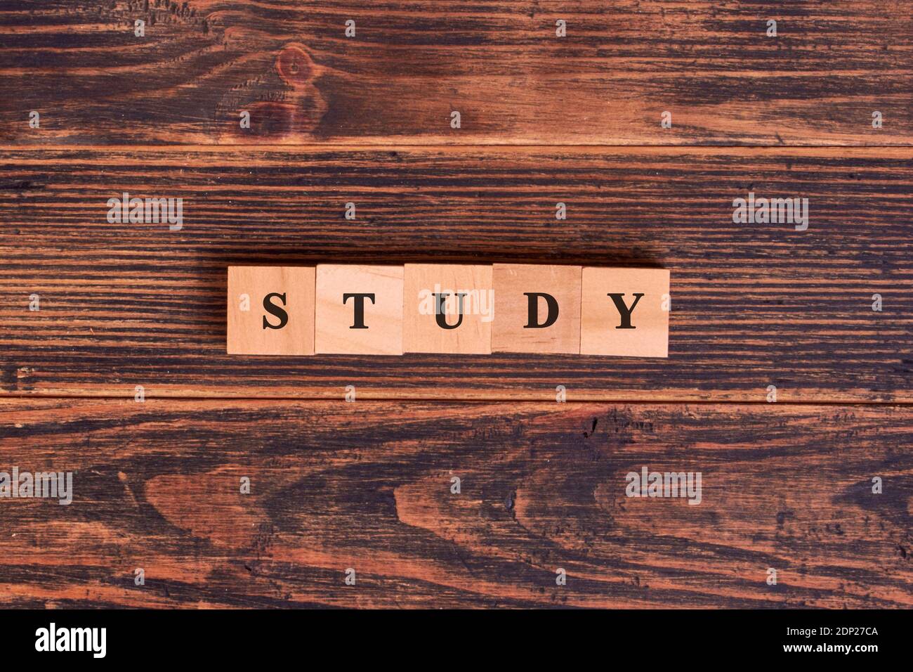 Study word lettering made of wooden cubes on dark rustic wooden background. Distance learning or Business concept Stock Photo