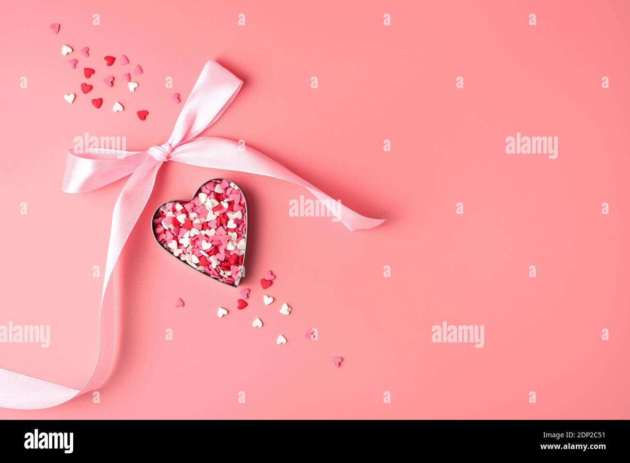 Heart with pink bow on pink background. Stock Photo
