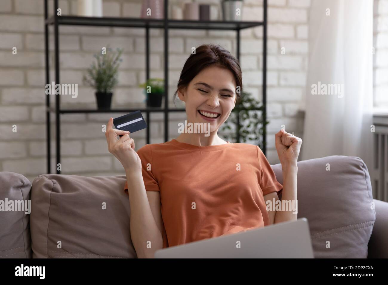 Happy millennial woman bank client satisfied with providing payment online Stock Photo