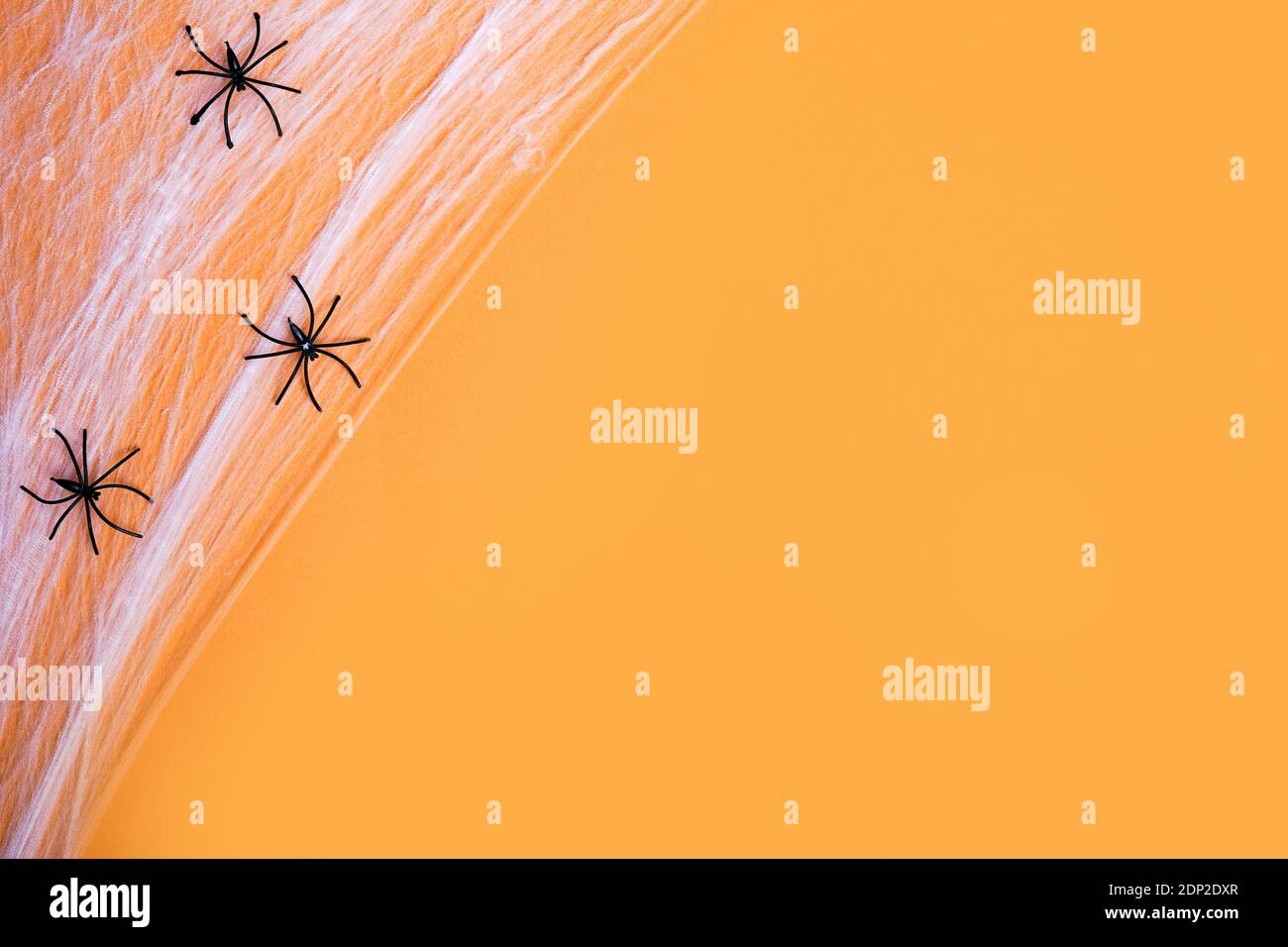 orange background for Halloween holiday with black spiders, copy space ...