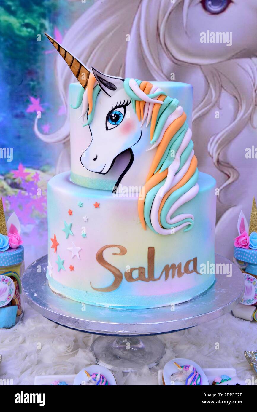 Pink birthday cake for girls.Detail of a birthday unicorn cake - focus on rainbow topper. Stock Photo