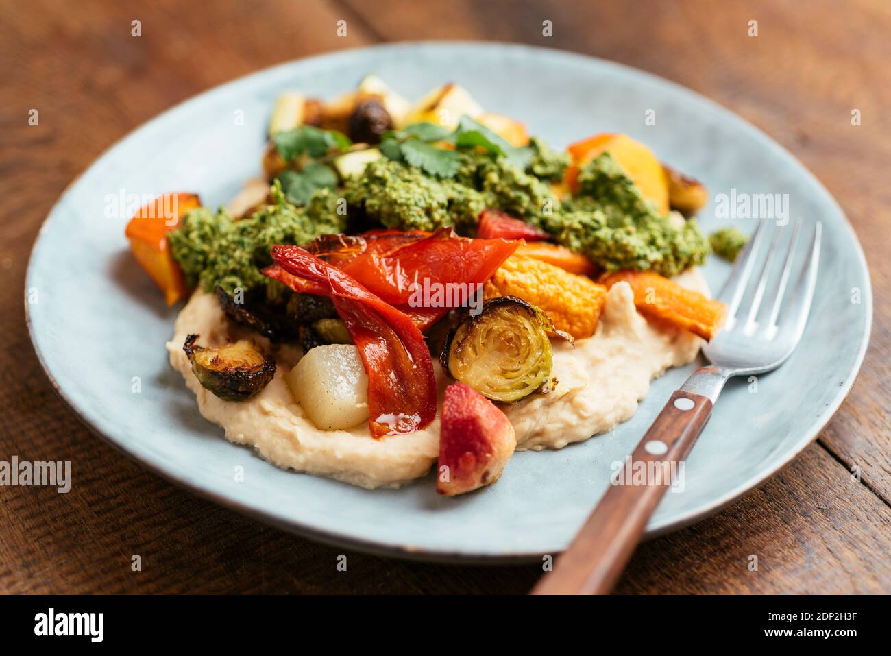 Roasted Vegetables on Butter Bean Hummus with Zhoug Stock Photo