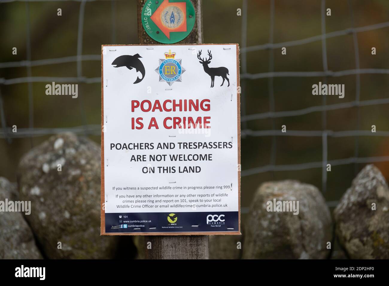 Sign on a footpath warning against poaching and trespassing on land in the countryside. Yorkshire Dales, UK. Stock Photo