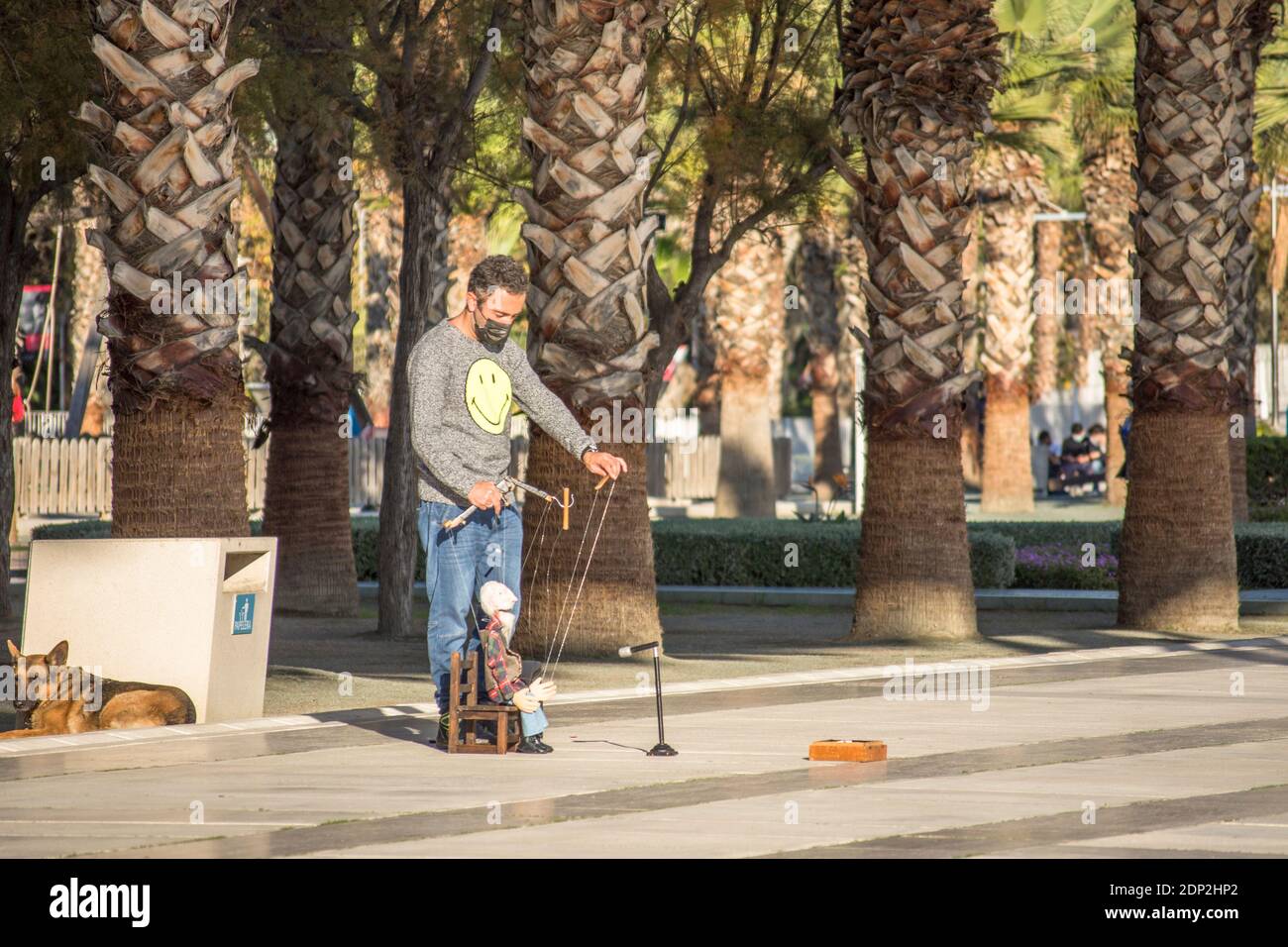 Street artist, puppeteer, wearing mask performing in street in Malaga