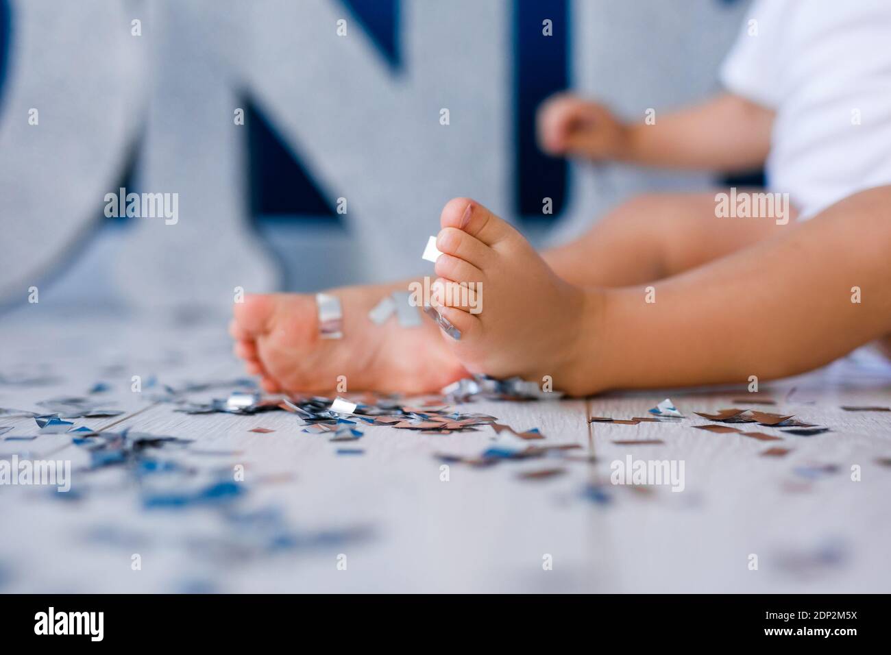One years old child's feet on high chair while he is eating at kitchen dinner table Stock Photo