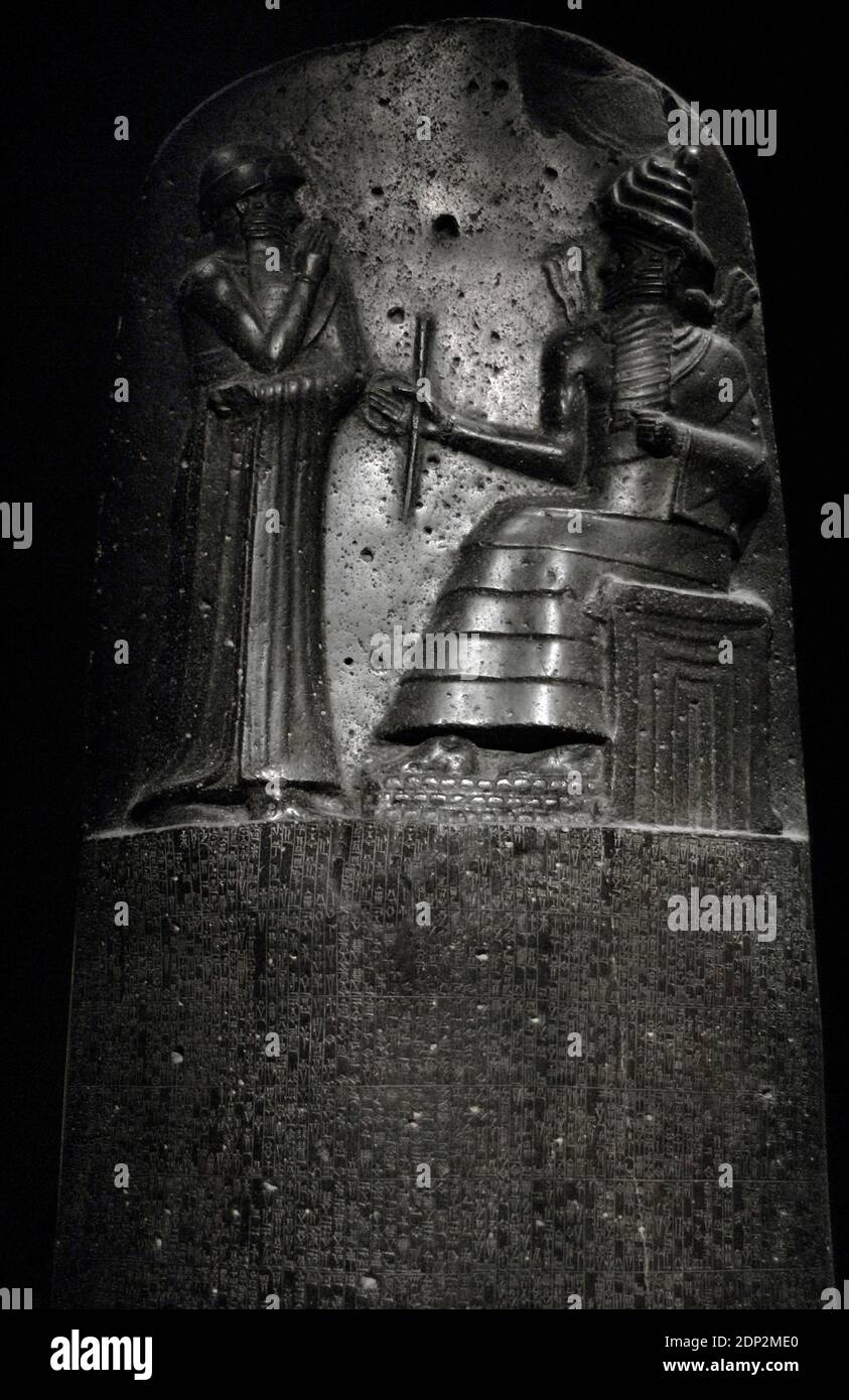 Law Code of Hammurabi, king of Babylon. Basalt stele, erected by King Hammurabi of Babylon (1792-1750 BC). Detail of the upper part. Relief depicting Hammurabi (standing) receiving his investiture from Shamash, god of justice. Louvre Museum. Paris, France. Stock Photo