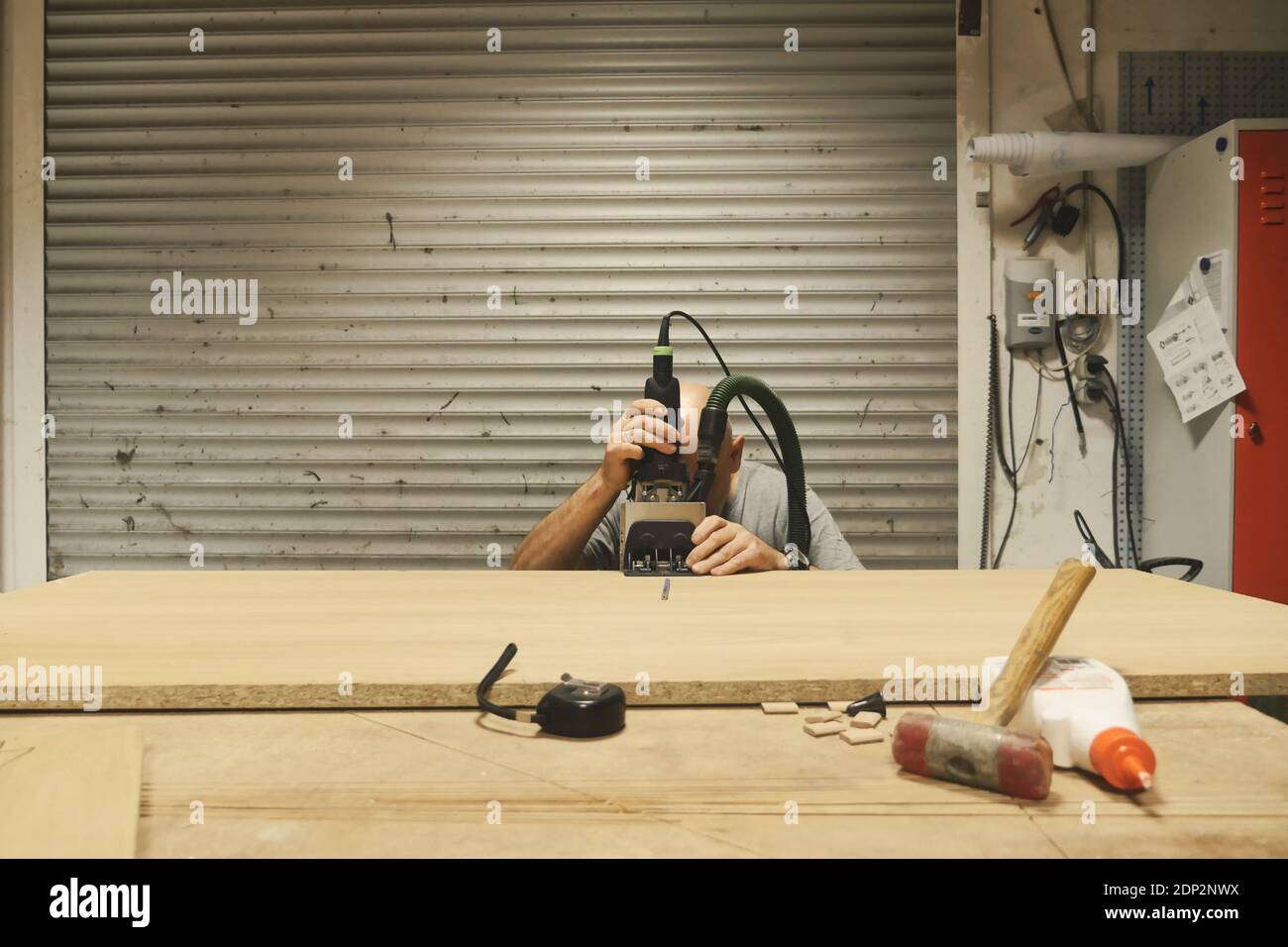 Carpenter using wood framing tool. Front view. Long shot Stock Photo