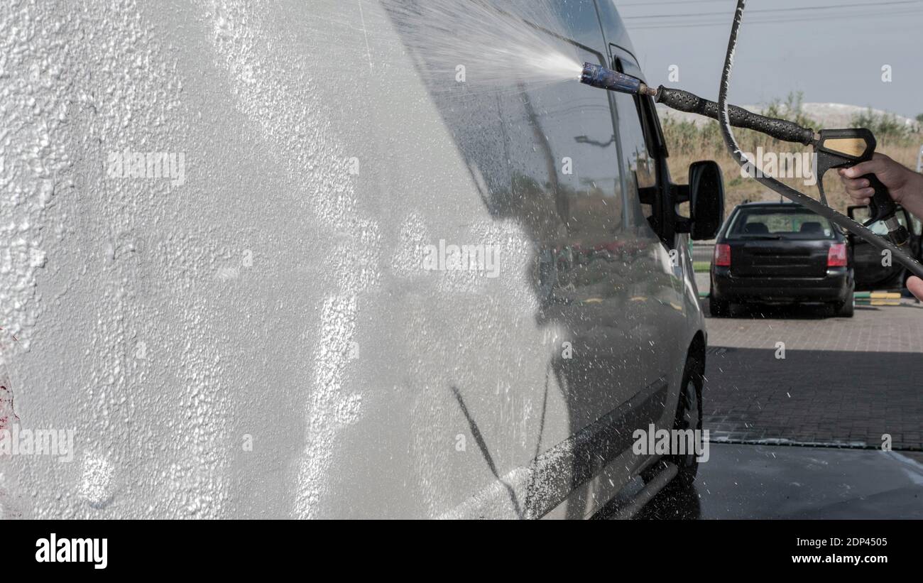Car wash, car wash worker washes the truck, the man foams the car