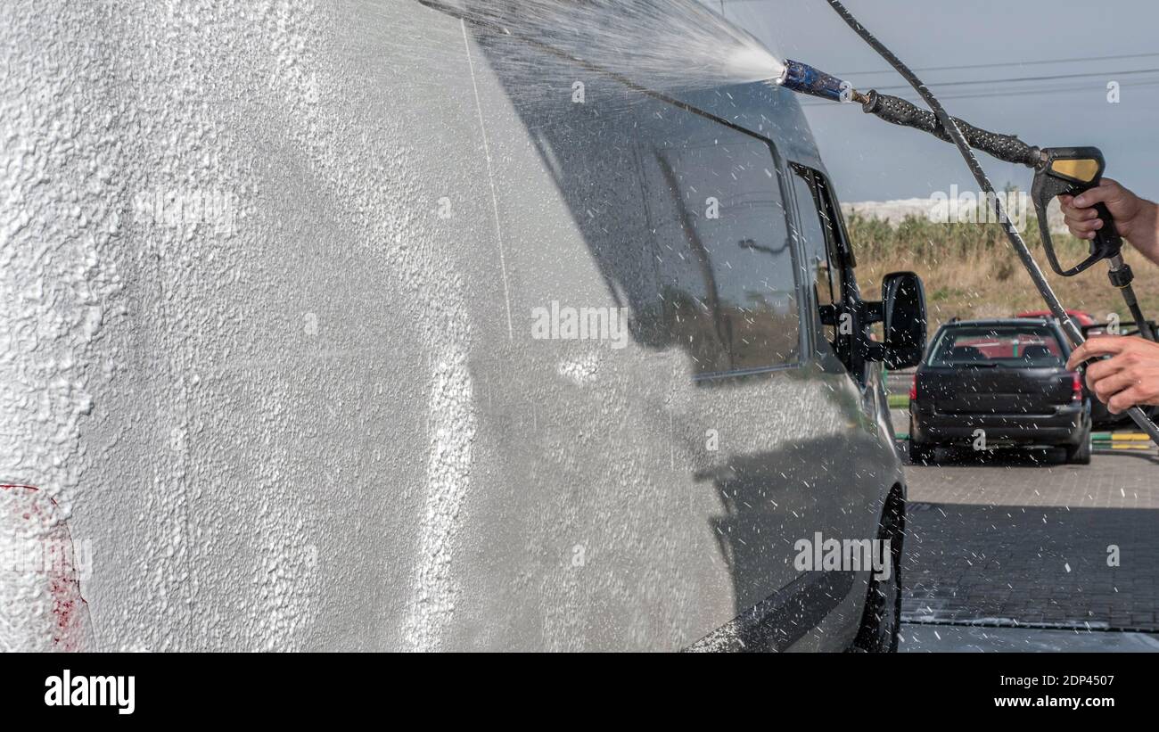 Car wash, car wash worker washes the truck, the man foams the car