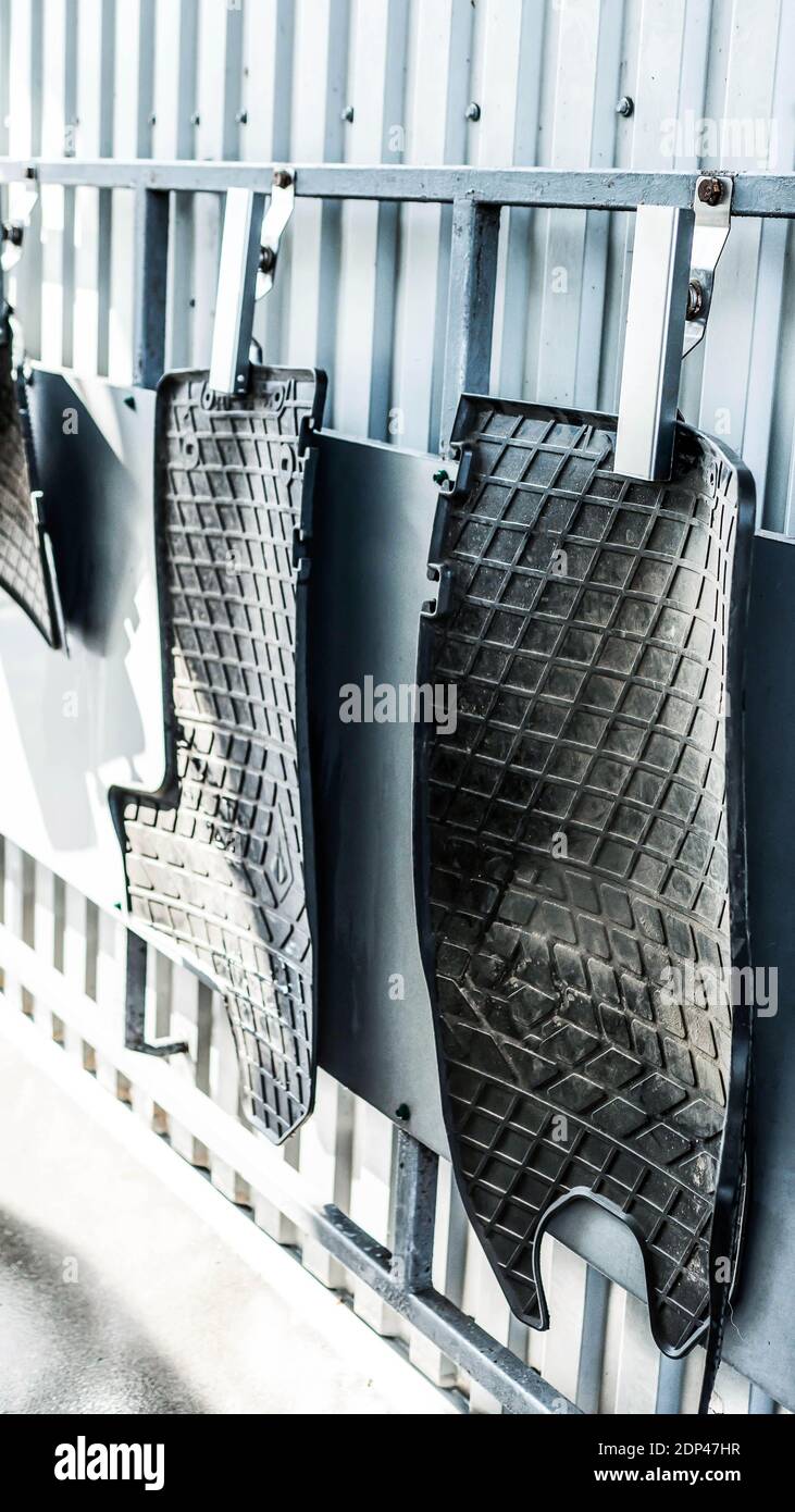 Car floor mats in a car wash attached to a clothespin,dirty car mats