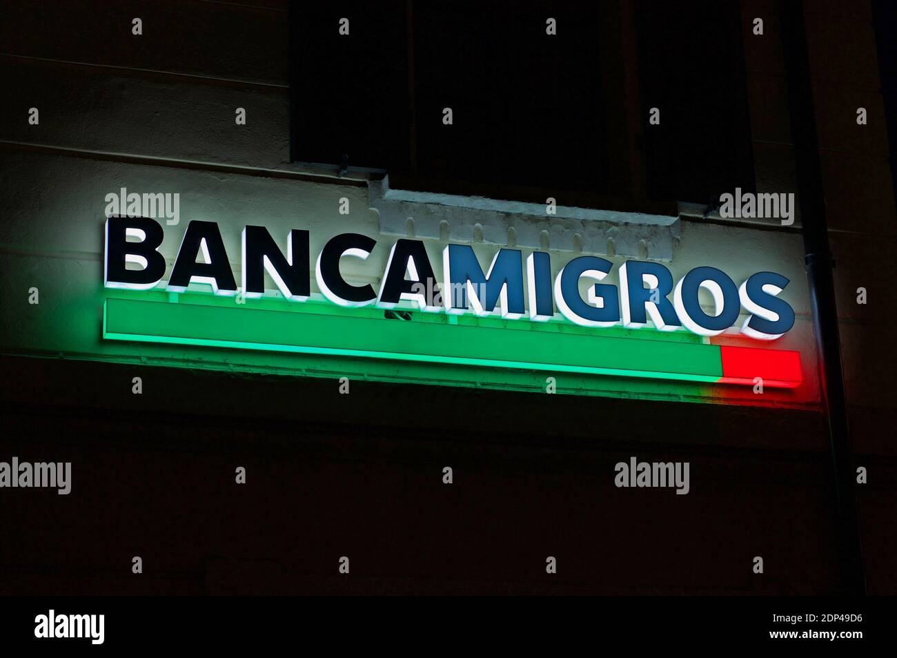 Lugano, Ticino, Switzerland - 25th November 2020 : Luminous Banca Migros (also known as Migros Bank) sign hanging on the building in the city of Lugan Stock Photo