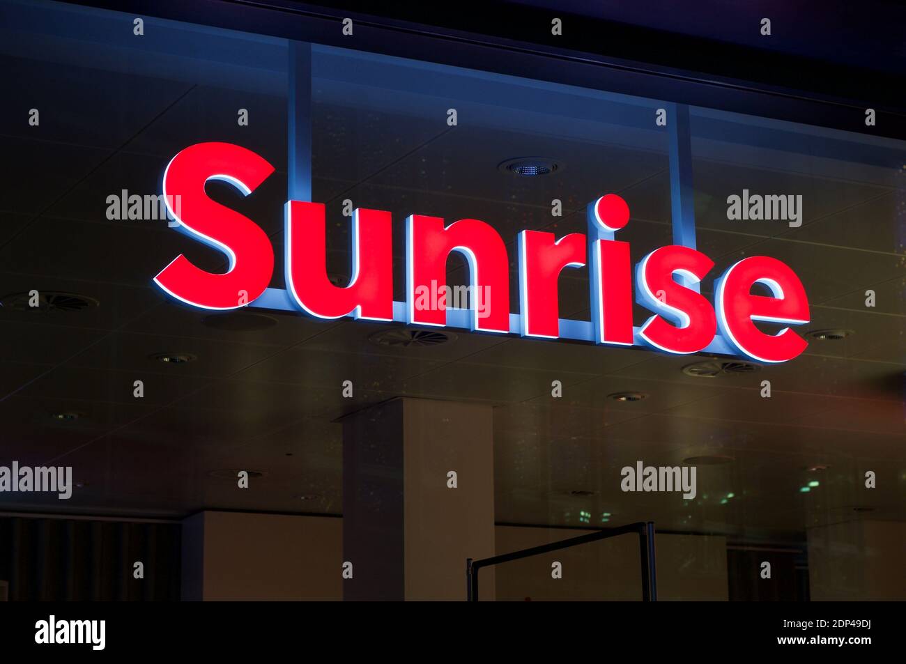 Lugano, Ticino, Switzerland - 26th November 2020 : Luminous Sunrise communications sign hanging in front of a store in Lugano. Sunrise is the second-l Stock Photo